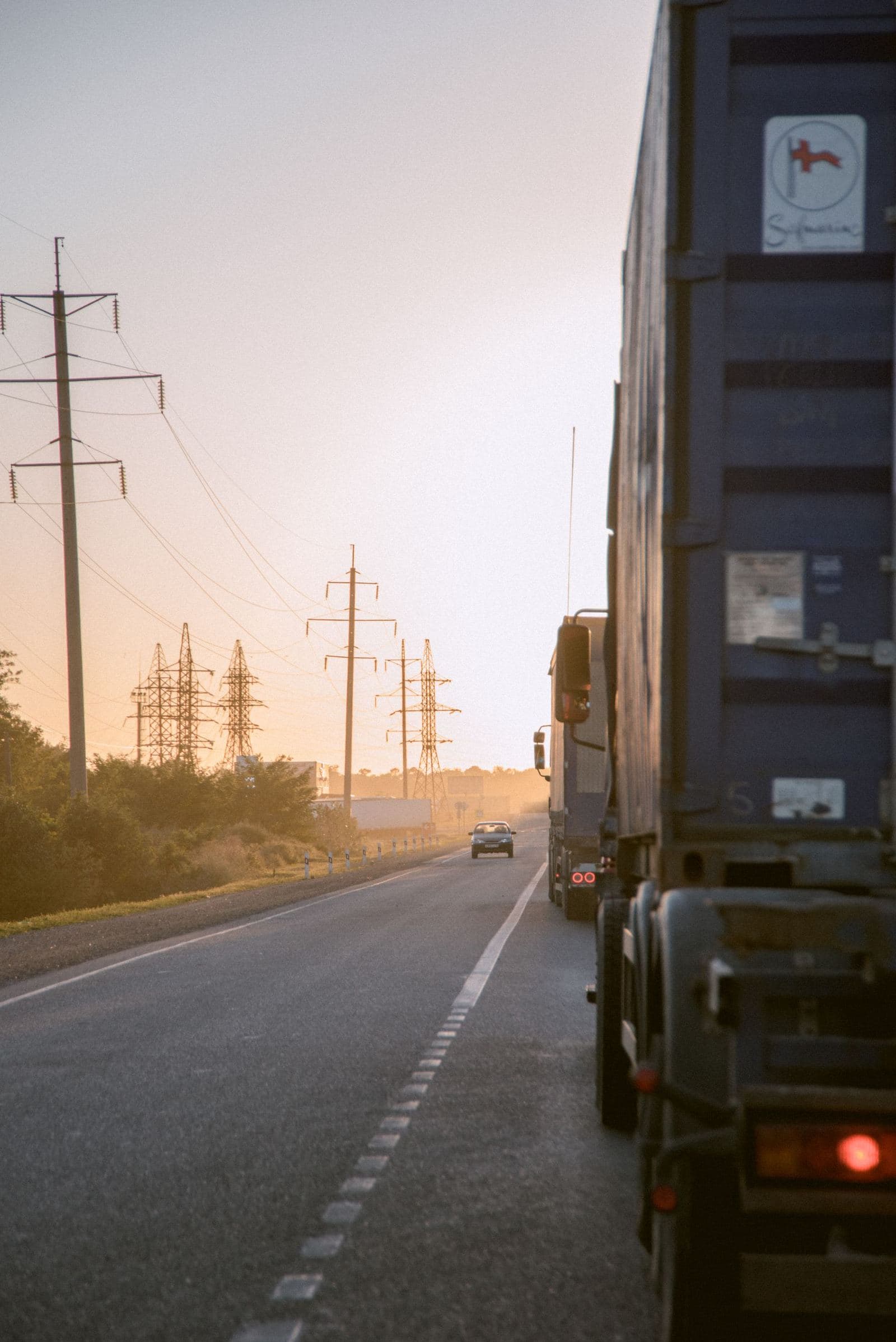 A semi truck waiting at sunset beside power lines, detention time on the clock
